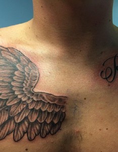 男性锁骨上的英文字和右胸部上的一只天使翅膀纹身图片